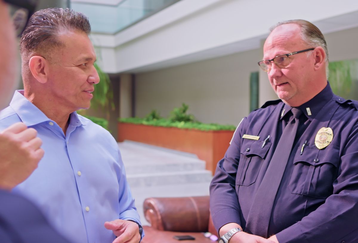 Dr. Willie Ng in conversation with a uniformed officer