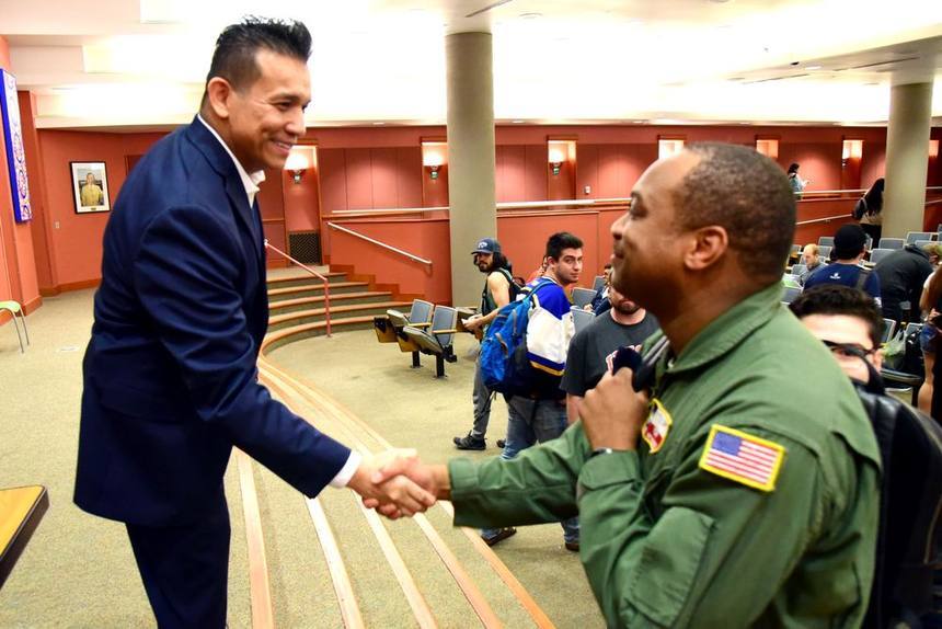 Dr. Willie Ng shaking hands with an attendee